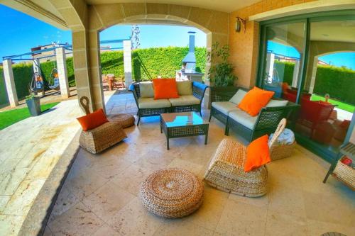 a patio with couches and chairs and a table at La Cantera Rural Spa in Viñaixa