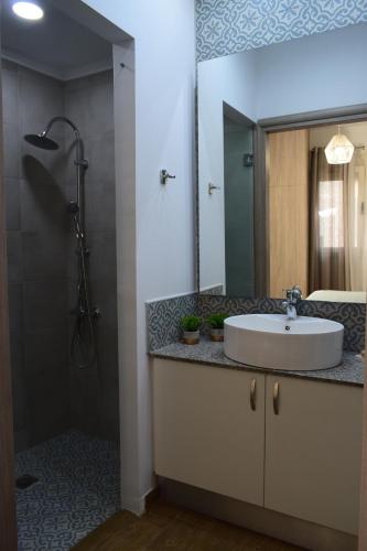 a bathroom with a sink and a shower with a mirror at Sweet Memories in Malia