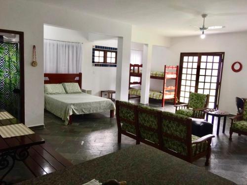 a bedroom with a bed and a living room at Casanapraia Bertioga in Bertioga