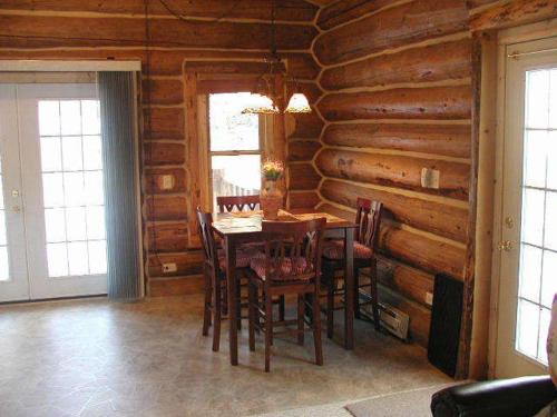 una sala da pranzo con tavolo e sedie in una baita di tronchi di Renegade Log Cabin a Custer