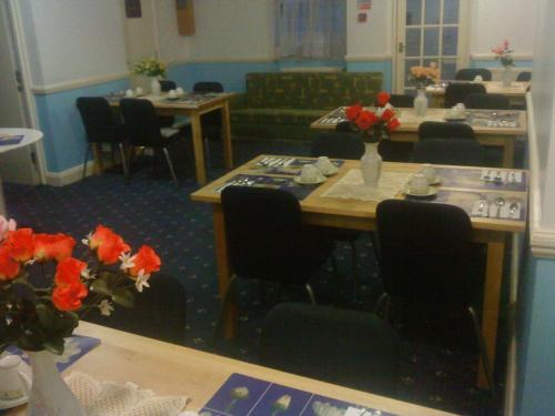 uma sala de jantar com mesa, cadeiras e flores em Hotel Sophia em Londres