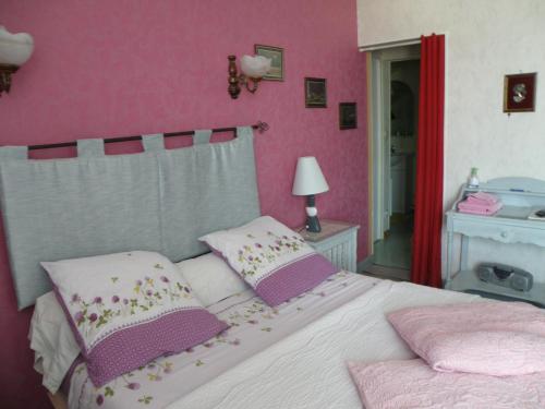 a bedroom with a white bed with pink walls at Chambres d'Hotes Le Pavillon du Charme in Cousances-aux-Forges