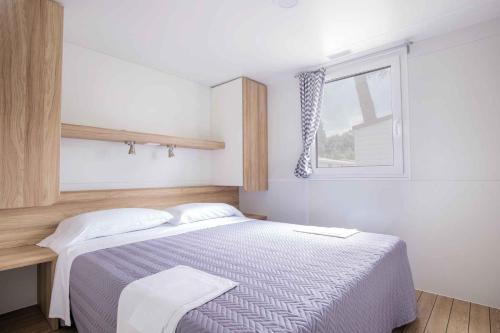 a small bedroom with a bed and a window at Villaggio Lido D'Abruzzo in Roseto degli Abruzzi