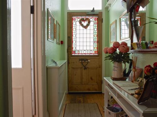 a hallway with a door and a vase of flowers at Chiltern Guest House in Whitby