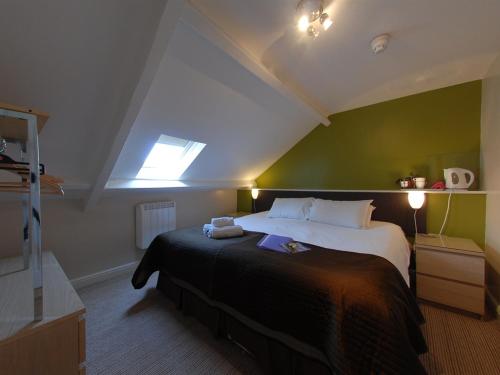 a bedroom with a large bed with a green wall at Chiltern Guest House in Whitby