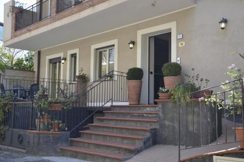 a house with stairs and potted plants on it at Hotel Marabel in SantʼAlessio Siculo