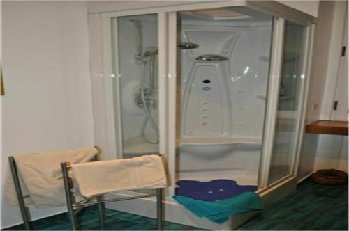 ein Bad mit einer Dusche, einem Stuhl und einer Dusche in der Unterkunft Colosseum Street in Rom