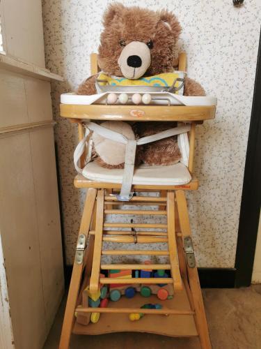 a teddy bear sitting in a high chair at B&B A la Ferme d'Ourches in Cerville
