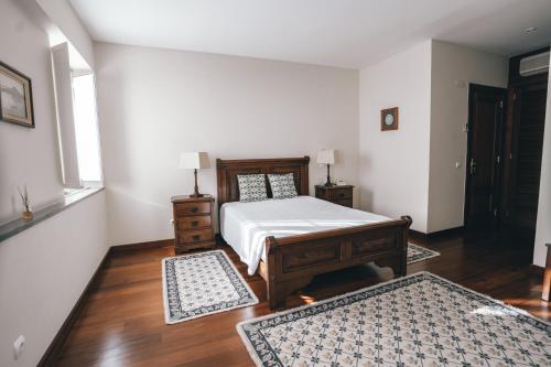 1 dormitorio con 1 cama y 2 alfombras en Quinta do Vale, en Horta