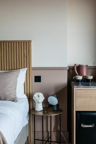 a bedroom with a bed and a table with a lamp at Port Hotel in Eastbourne