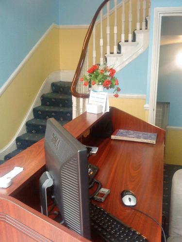 a desk with a computer on it with a staircase at Hotel Sophia in London