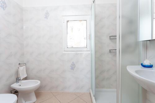 La salle de bains est pourvue d'une douche, de toilettes et d'un lavabo. dans l'établissement Nicola House Il Faro, à Cervia