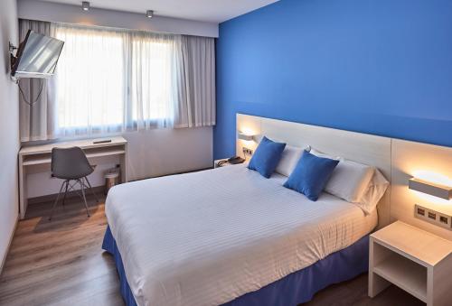 a hotel room with a large bed and a desk at Hotel Julimar in Lloret de Mar