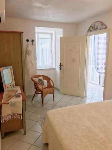 a room with a bed and a chair and a door at PonzaSmeralda Le Forna in Ponza