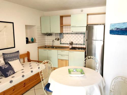 a small kitchen with a table and chairs in a room at PonzaSmeralda Le Forna in Ponza