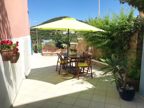 a table and chairs under an umbrella on a patio at PonzaSmeralda Le Forna in Ponza