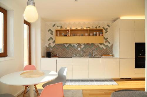 a kitchen with a white table and chairs at Casa do Pilar - D Maria Pia in Vila Nova de Gaia