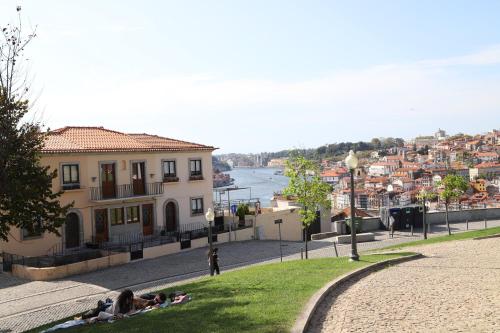 a group of people laying on the grass near a building at Casa do Pilar - D Maria Pia in Vila Nova de Gaia