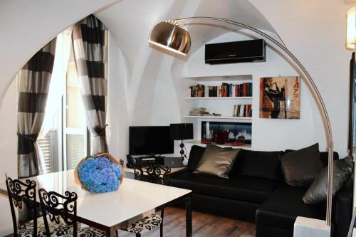 een woonkamer met een zwarte bank en een tafel bij Casa Giorgia luxury apartment in Rome