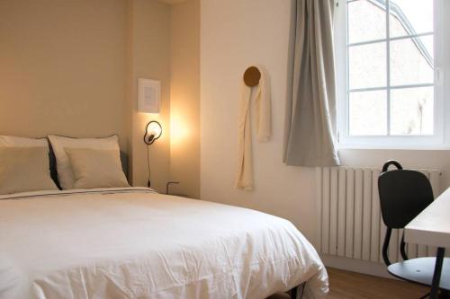 une chambre avec un lit, une fenêtre et un bureau dans l'établissement L'ingénieux de Bazin - proche Place Stanislas, à Nancy