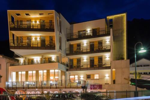 a building with balconies and cars parked in front of it at Kleinkunsthotel in Naturno