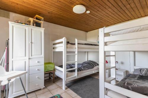 Zimmer mit 2 Etagenbetten und einem Schreibtisch in der Unterkunft Deichgraf 2 in Friedrichskoog