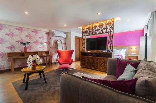 a living room with a couch and a television in a room at FCH Hotel Providencia in Guadalajara