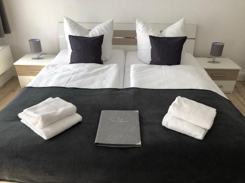 a bed with two white towels and a laptop on it at Pension Altstadt in Weimar