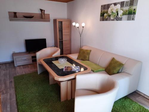 a living room with a couch and a table at Lacky - kleines Familienreihenmittelhaus in Grieben Hiddensee in Grieben