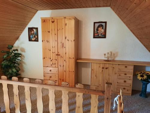 GriebenにあるLacky - kleines Familienreihenmittelhaus in Grieben Hiddenseeの木製のキャビネットと階段が備わる客室です。