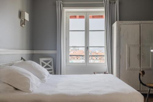 a bedroom with a bed and a window at Hotel Saint Julien in Biarritz