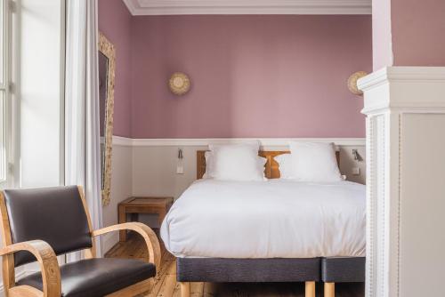 1 dormitorio con 1 cama y 1 silla en Hotel Saint Julien en Biarritz