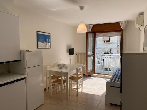 a kitchen and dining room with a table and a refrigerator at Europa Unita Apartment in Grado