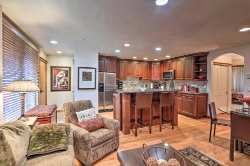 a large kitchen with wooden cabinets and a living room at Updated Condo Walk to Vail Village and Ski Shuttle! in Vail