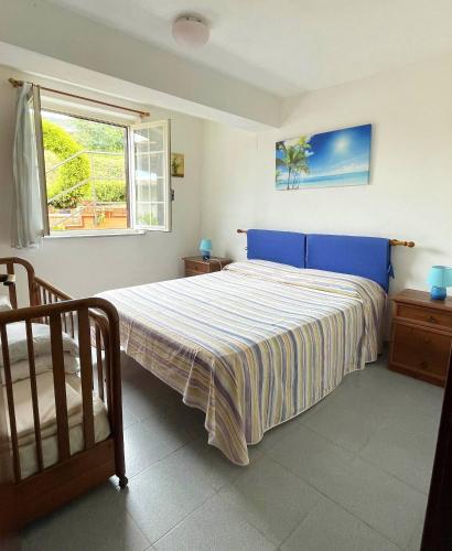 a bedroom with a bed with a blue headboard and a window at Goddess Yard in Tropea