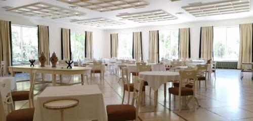 a dining room with tables and chairs and windows at Hotel Termas da Curia in Curia