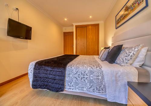 a bedroom with a bed and a flat screen tv at Casa D'Olga in Lagos