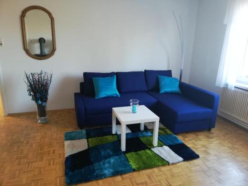 a living room with a blue couch and a table at Apartment Graz Lustbuhel in Graz