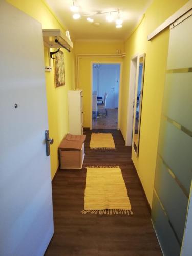 a hallway with yellow walls and yellow rugs at Apartment Graz Lustbuhel in Graz