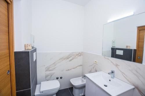 a white bathroom with a sink and a toilet at Residence Daniele in Bellaria-Igea Marina