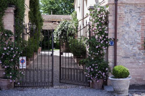 an iron gate with flowers on it next to a building at Villino di Porporano in Parma