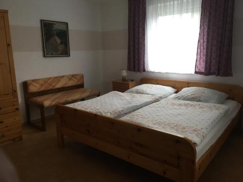 ein Schlafzimmer mit einem Holzbett und einem Fenster in der Unterkunft Ferienwohnung Gaby Familie Wichtl in Riedlhütte