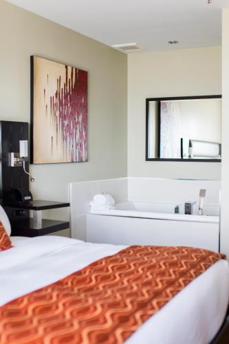a hotel room with a bed and a bathroom at Hotel Levesque in Rivière-du-Loup