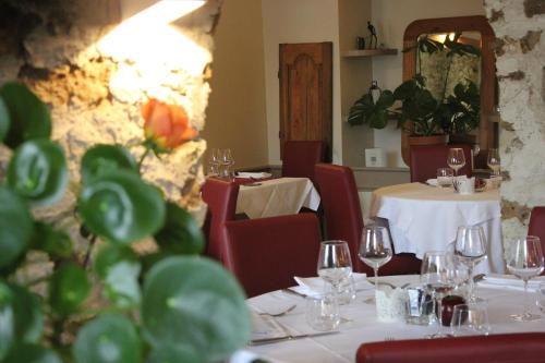a dining room with tables and chairs with glasses and tablesearcher at Logis Hôtel - Le Manoir de Sauvegrain in Saint-Lambert