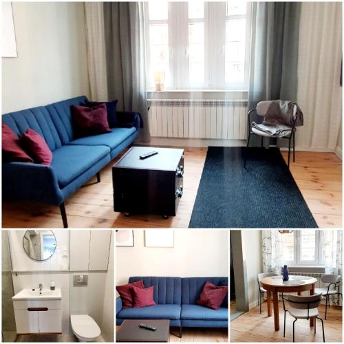 a living room with a blue couch and a table at Loft Rooms - Apartamenty w Kamienicy centrum, bezpłatny parking in Ełk