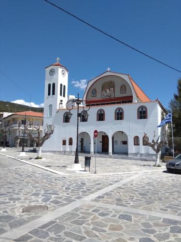 a large white building with a clock tower at 3SSS Bouquet Studios in Marmarion