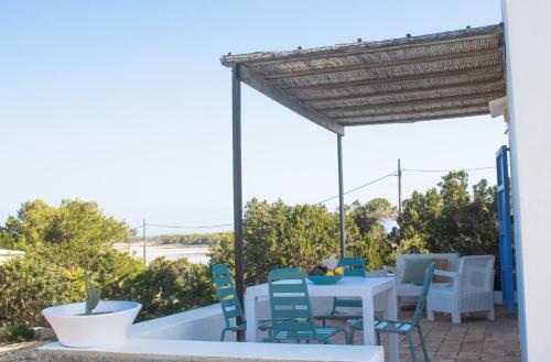 un patio con tavolo, sedie e vista sull'oceano di Cas Saliners - Parc Natural a La Savina
