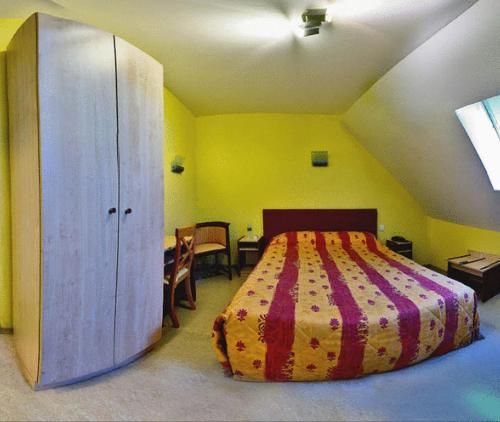 a bedroom with a large bed in a yellow room at Relais Du Lac in Villegusien Le Lac