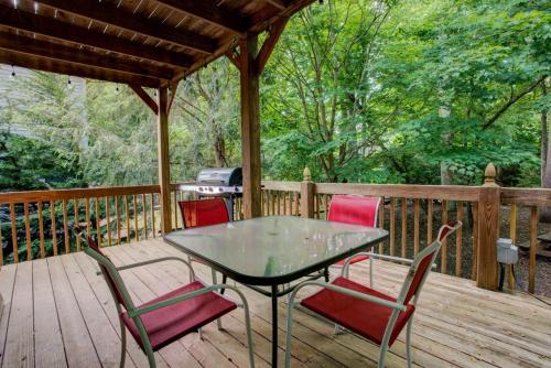 a table and chairs on a deck with a grill at Bearadise on the Creek in Maggie Valley
