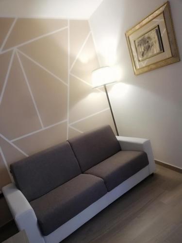 a couch in the corner of a room with a lamp at Royal Dreams in Caserta